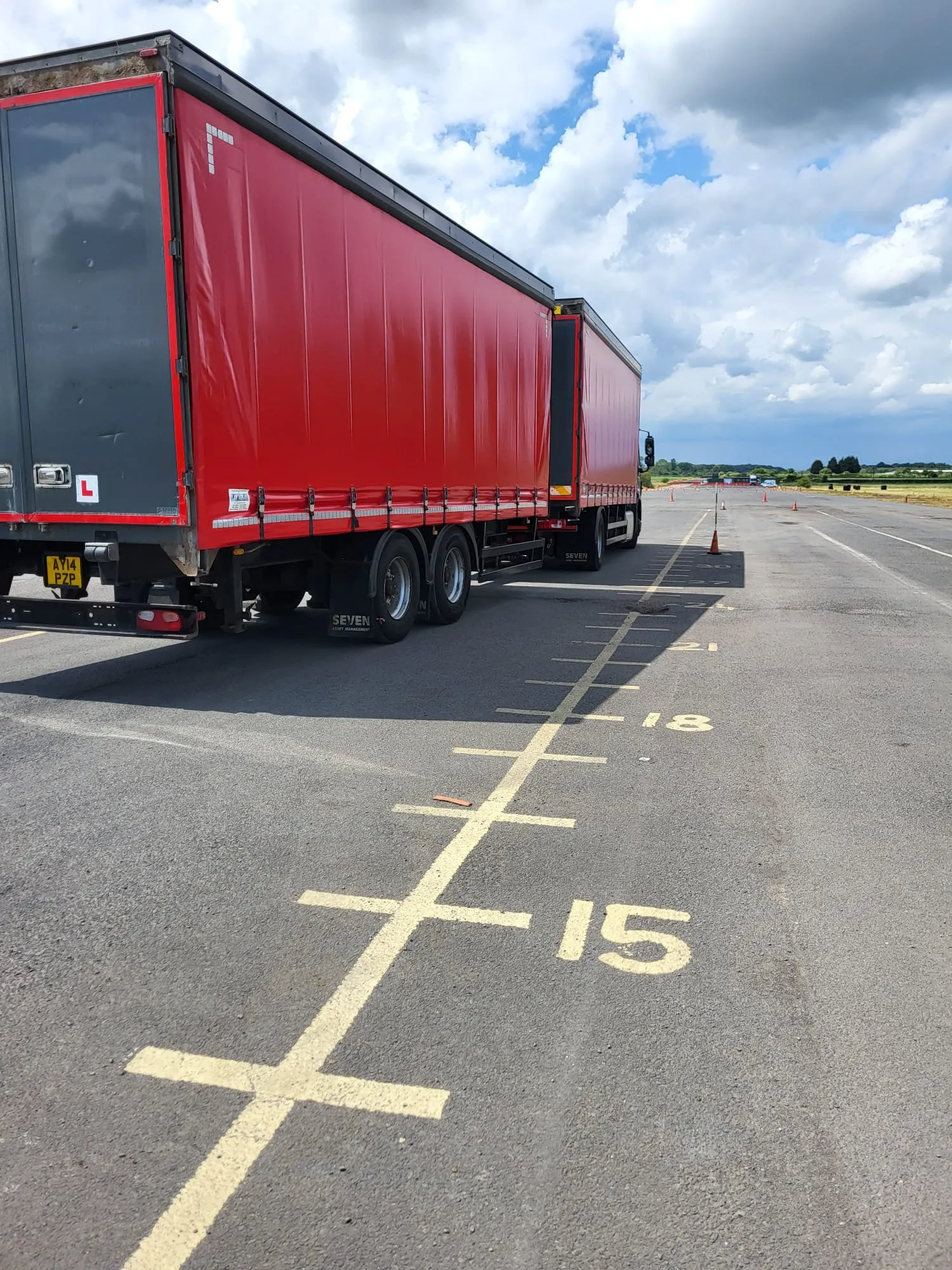 A red semi truck parked in a parking lot.