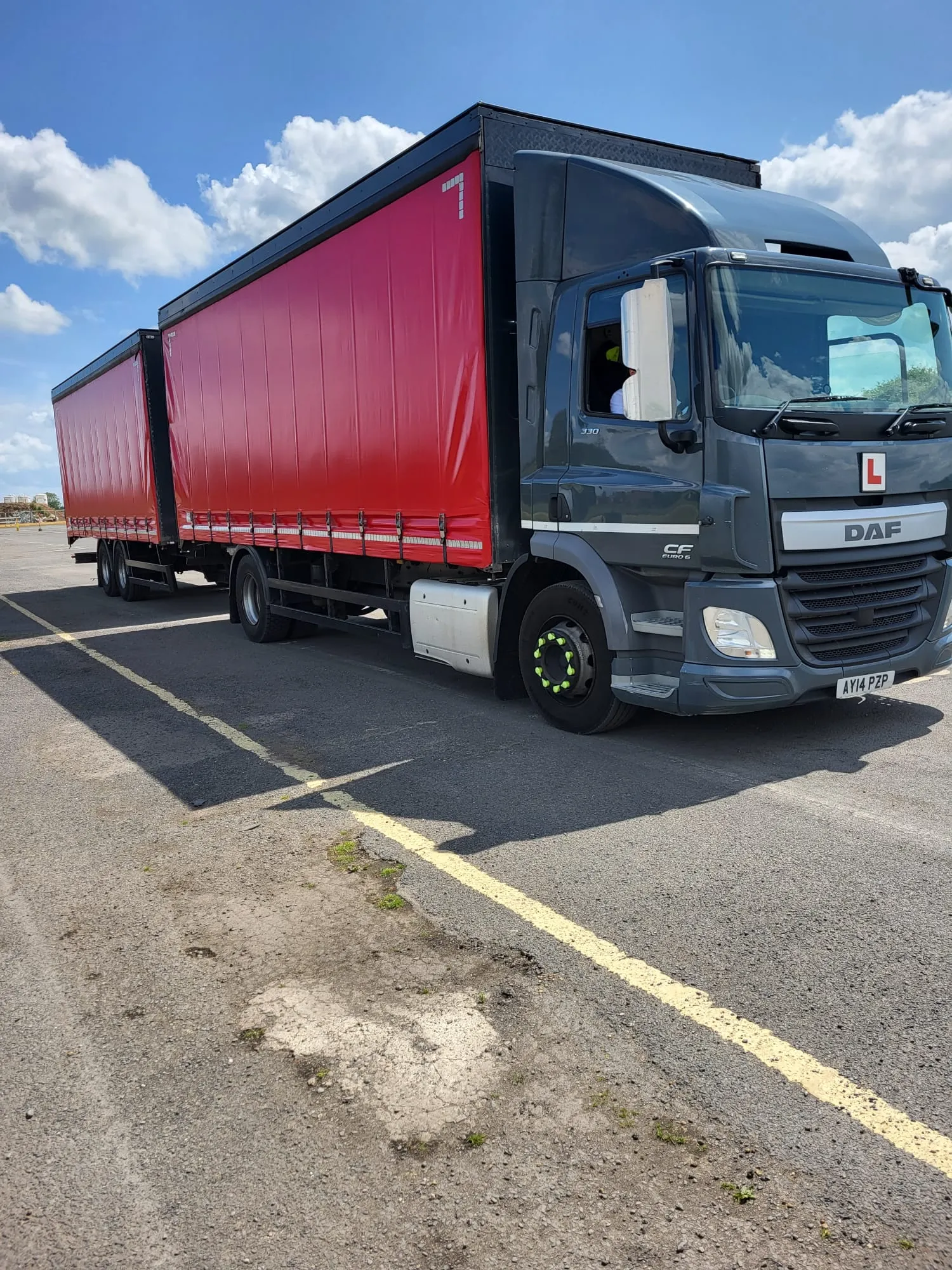 A red and black semi truck parked in a parking lot.