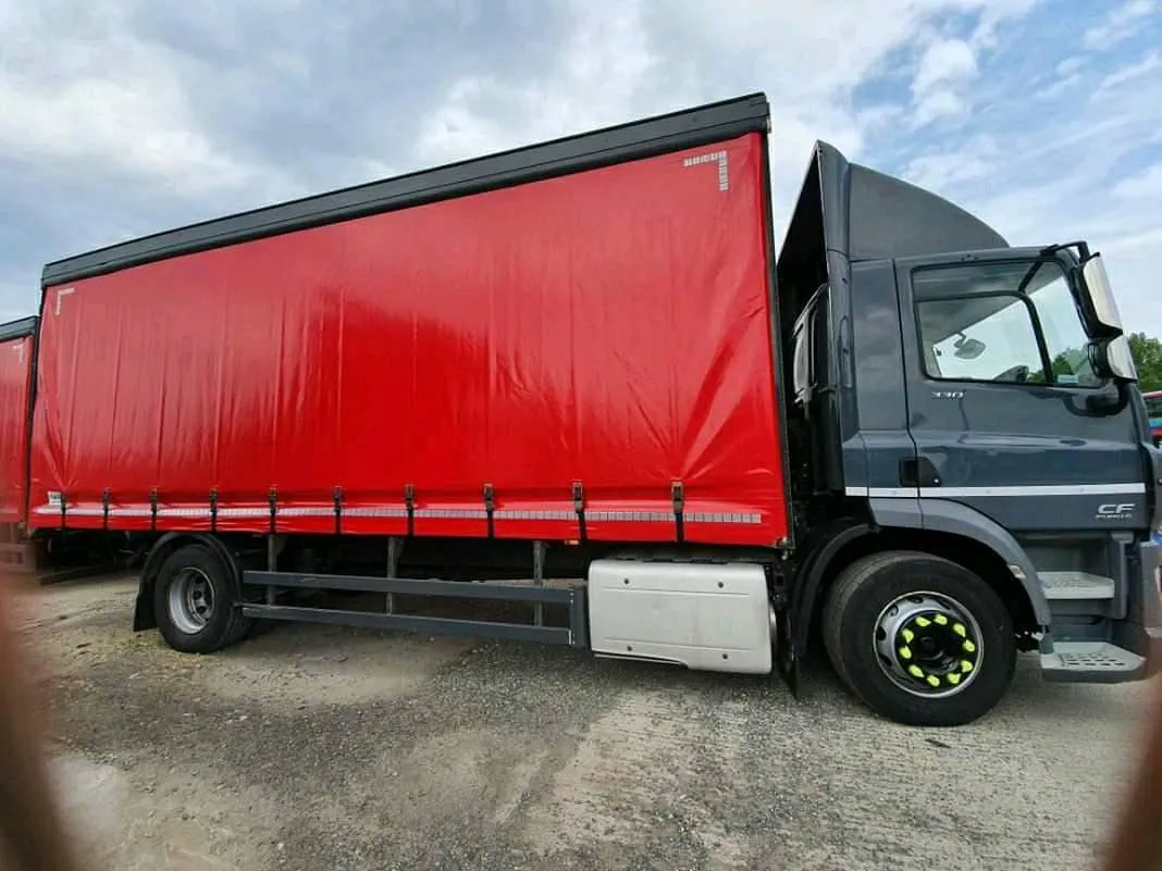 A red and black truck parked in a parking lot.