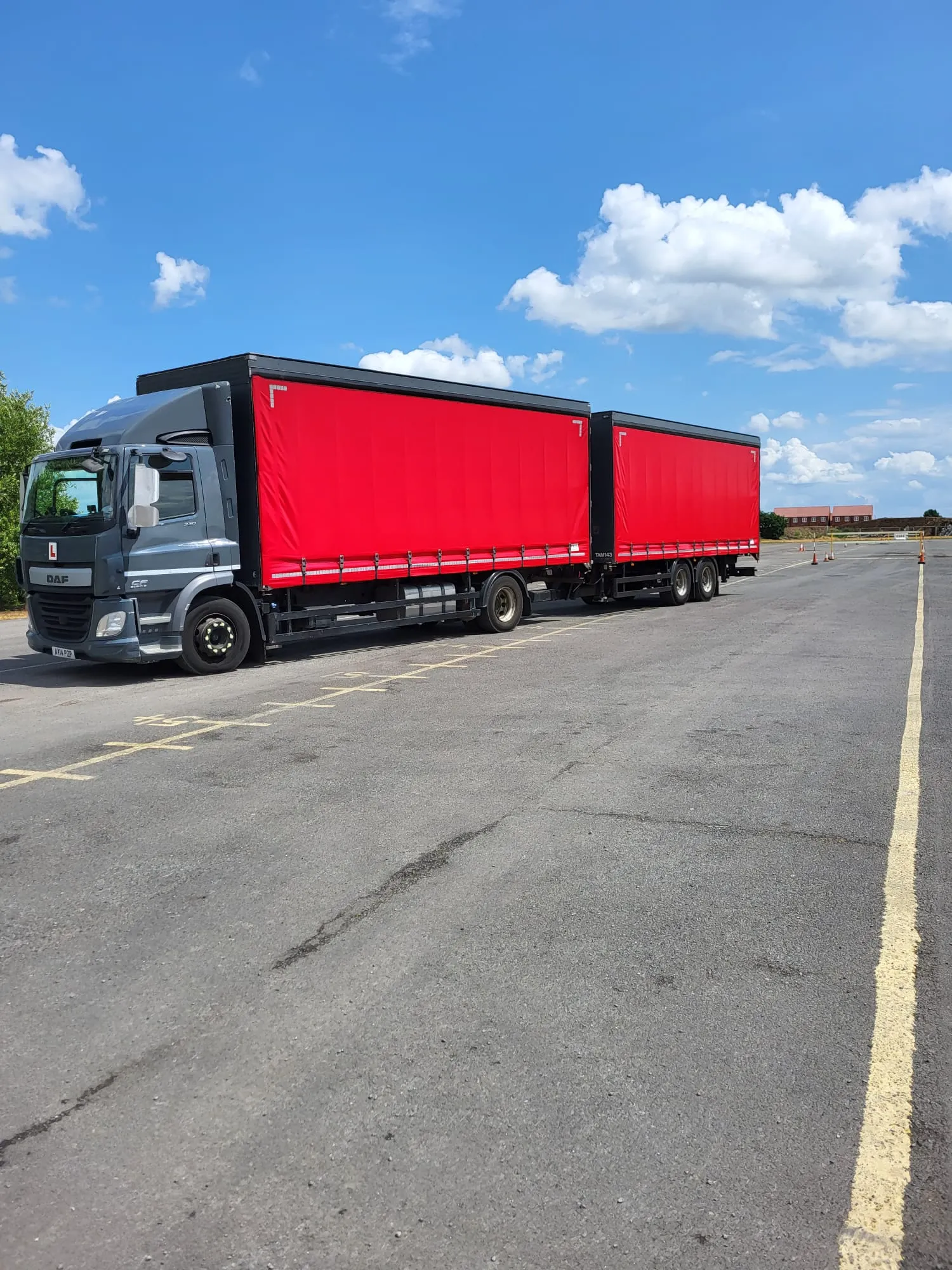 A large semi truck with a red trailer.
